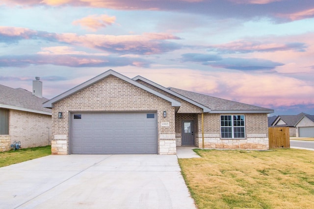 ranch-style house with a garage and a lawn