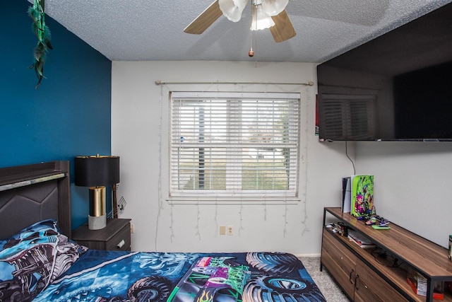 carpeted bedroom featuring ceiling fan and a textured ceiling