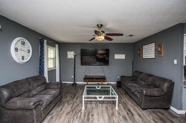 living room featuring a textured ceiling, wood-type flooring, and ceiling fan