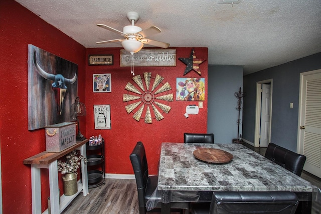 dining room with dark hardwood / wood-style flooring, ceiling fan, and a textured ceiling