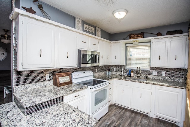 kitchen featuring backsplash, white cabinets, sink, and white range with electric stovetop