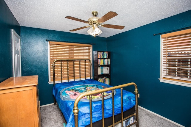 carpeted bedroom with ceiling fan and a textured ceiling