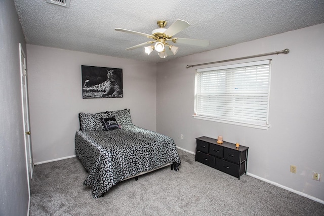 carpeted bedroom with ceiling fan and a textured ceiling