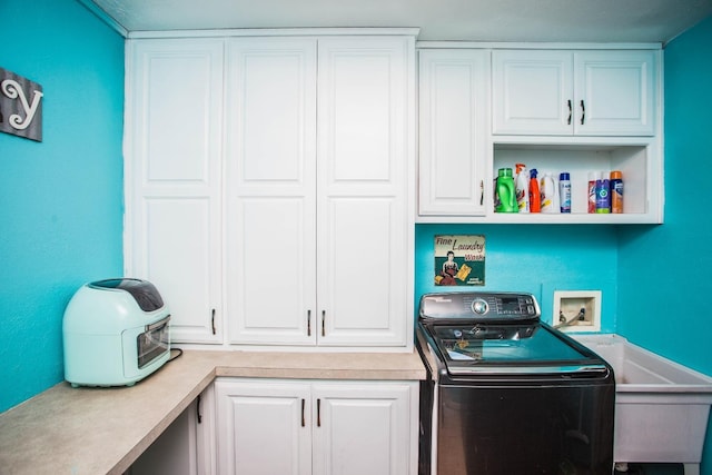 clothes washing area with washer / clothes dryer and cabinets