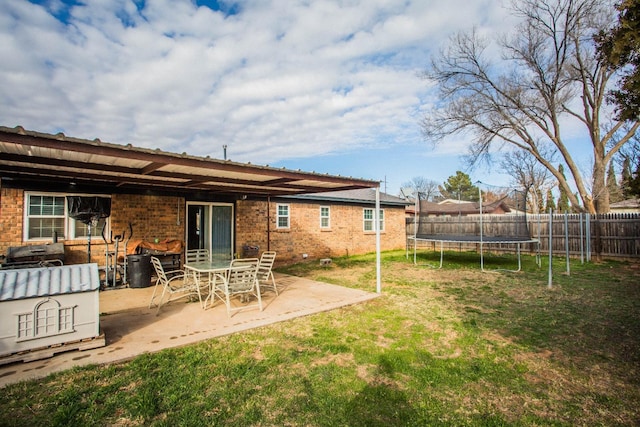 view of yard with a trampoline and a patio