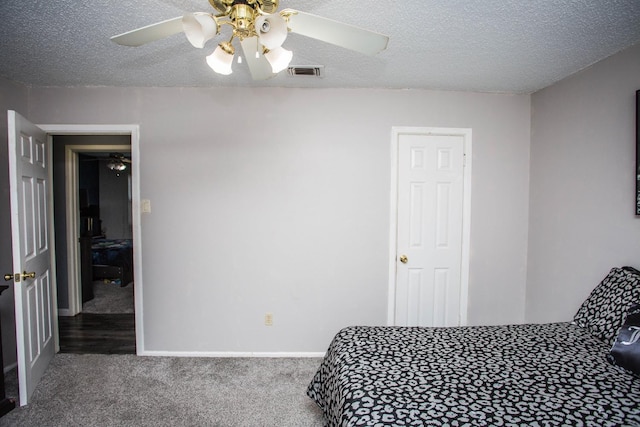 bedroom featuring ceiling fan, carpet, and a textured ceiling