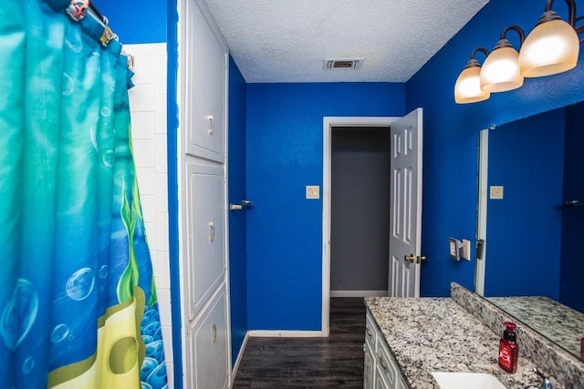 bathroom with vanity, hardwood / wood-style floors, and a textured ceiling