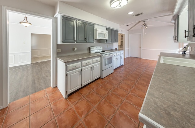 kitchen with sink, dark tile patterned floors, hanging light fixtures, ceiling fan, and white appliances