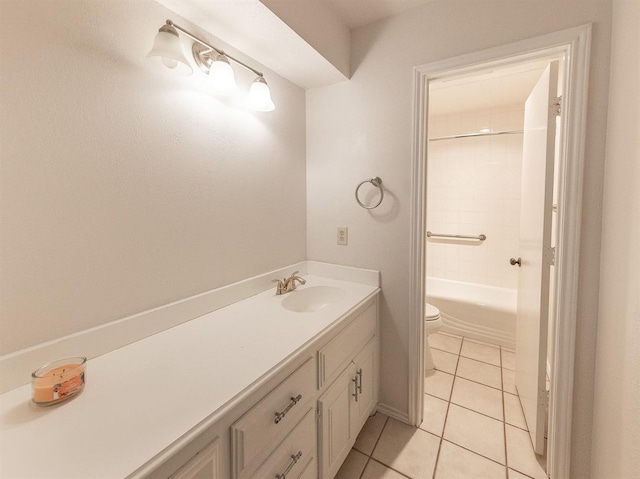 full bathroom featuring tile patterned flooring, vanity, tiled shower / bath, and toilet