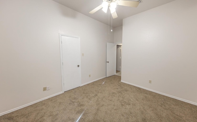 spare room featuring ceiling fan and light carpet