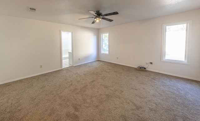 carpeted spare room featuring ceiling fan