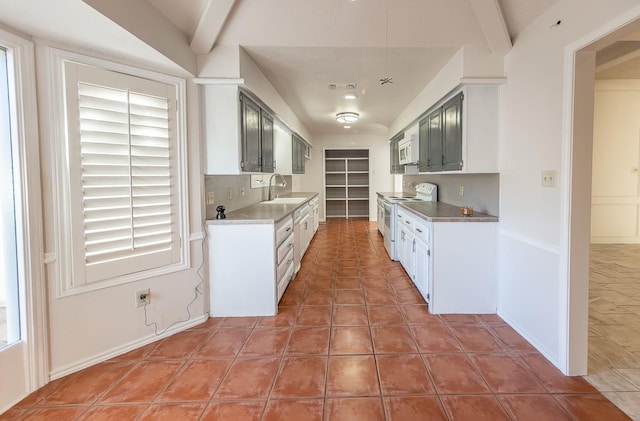 kitchen featuring a healthy amount of sunlight, white appliances, tile patterned floors, and sink