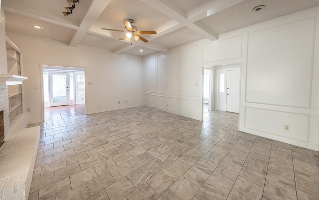 tiled empty room with beamed ceiling, ceiling fan, coffered ceiling, and a fireplace