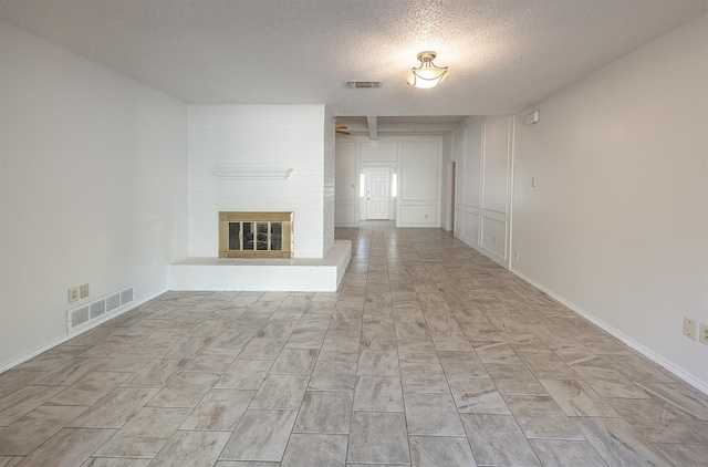 unfurnished living room with a brick fireplace and a textured ceiling