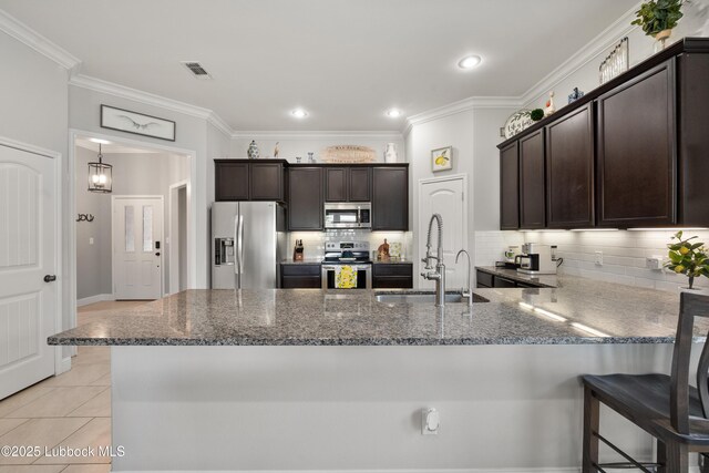 3634 Ridgely Ave, Lubbock, TX 79407 - kitchen with appliances with stainless steel finishes, dark stone countertops, dark brown cabinets, crown molding, and recessed lighting