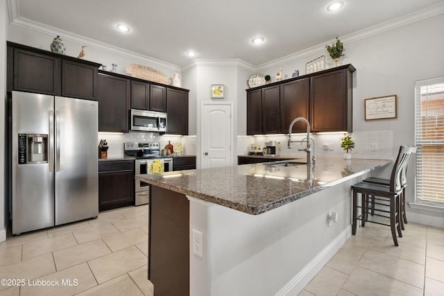 3634 Ridgely Ave, Lubbock, TX 79407 - kitchen featuring appliances with stainless steel finishes, dark brown cabinets, dark stone countertops, light tile patterned flooring, and ornamental molding