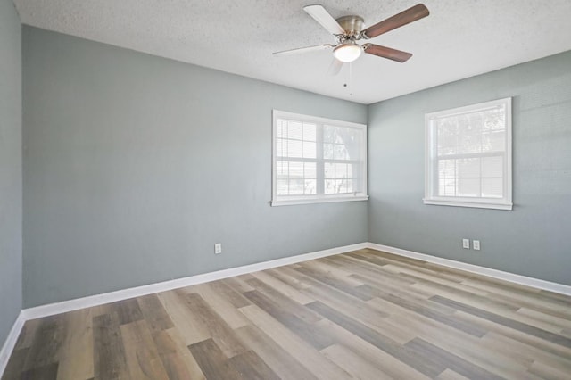 empty room with ceiling fan, light hardwood / wood-style floors, and a textured ceiling