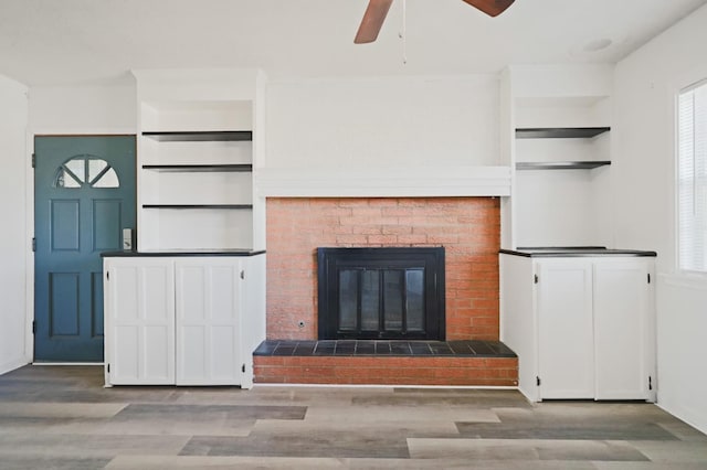 unfurnished living room with ceiling fan, a fireplace, and hardwood / wood-style floors