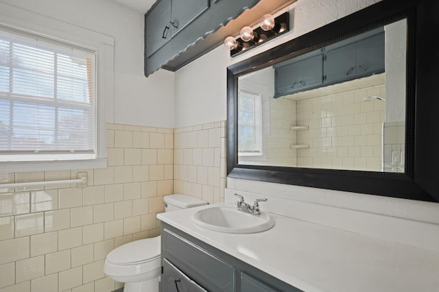 bathroom featuring vanity, a shower, tile walls, and toilet