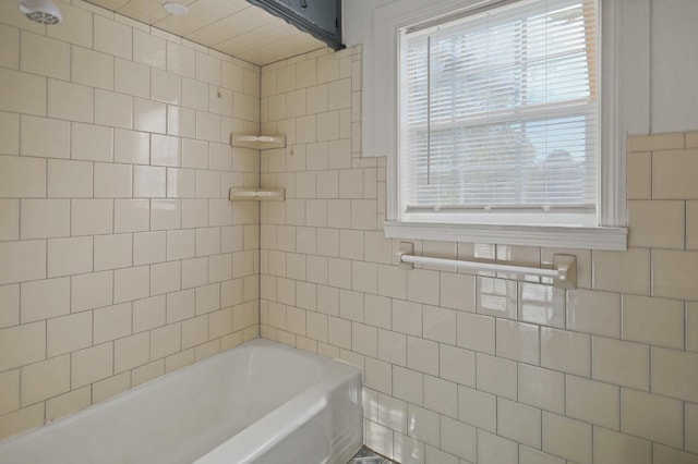 bathroom featuring tile walls and tiled shower / bath combo