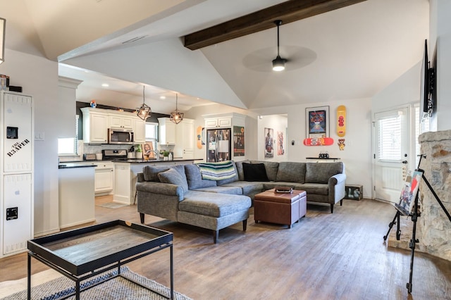 living room with beamed ceiling, ceiling fan, high vaulted ceiling, and light hardwood / wood-style floors