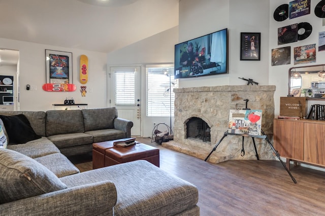 living room featuring lofted ceiling, hardwood / wood-style floors, and a fireplace