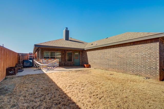 rear view of house with a yard and a patio area