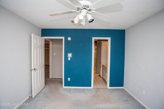 5110 1st Pl, Lubbock, TX 79416 - unfurnished bedroom with light carpet, baseboards, a textured ceiling, a ceiling fan, and connected bathroom