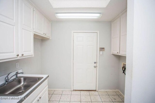 5110 1st Pl, Lubbock, TX 79416 - laundry room featuring washer hookup, cabinet space, baseboards, and light tile patterned floors