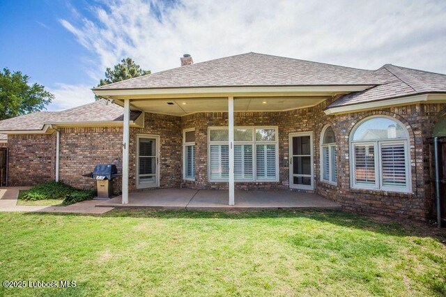 5110 1st Pl, Lubbock, TX 79416 - rear view of house featuring brick siding, a lawn, a patio, a chimney, and roof with shingles