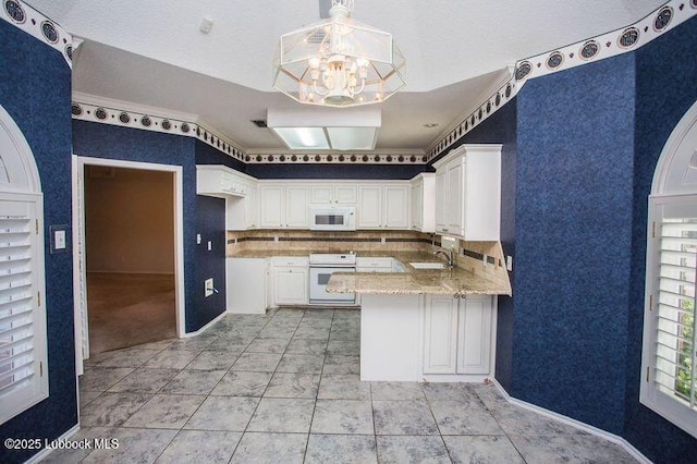 5110 1st Pl, Lubbock, TX 79416 - kitchen with stove, white microwave, a sink, a chandelier, and a peninsula