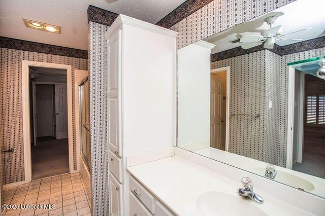 5110 1st Pl, Lubbock, TX 79416 - bathroom with wallpapered walls, vanity, ceiling fan, tile patterned flooring, and combined bath / shower with glass door
