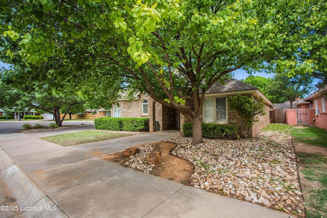 5110 1st Pl, Lubbock, TX 79416 - obstructed view of property featuring driveway, brick siding, and a gate