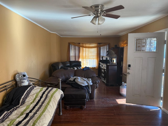 bedroom featuring dark wood-type flooring, ceiling fan, and ornamental molding