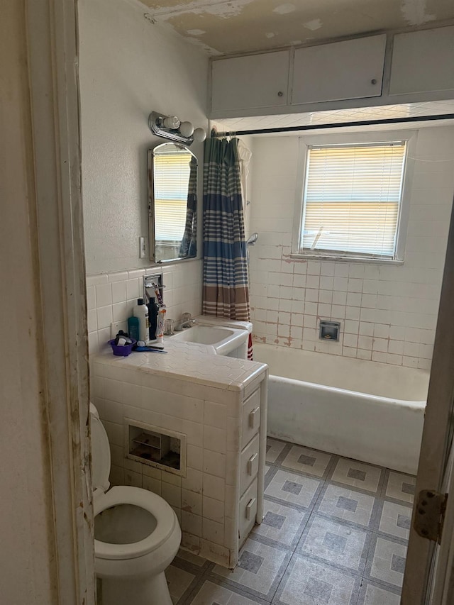 full bathroom featuring vanity, toilet, tile walls, and shower / bath combo