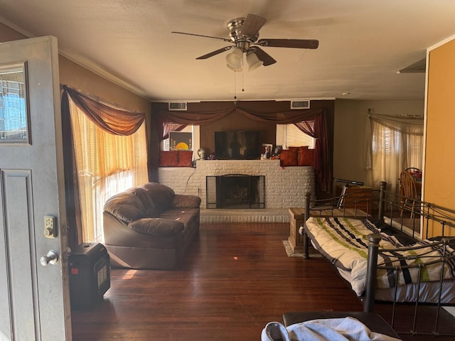 living room featuring ceiling fan, a fireplace, and dark hardwood / wood-style floors