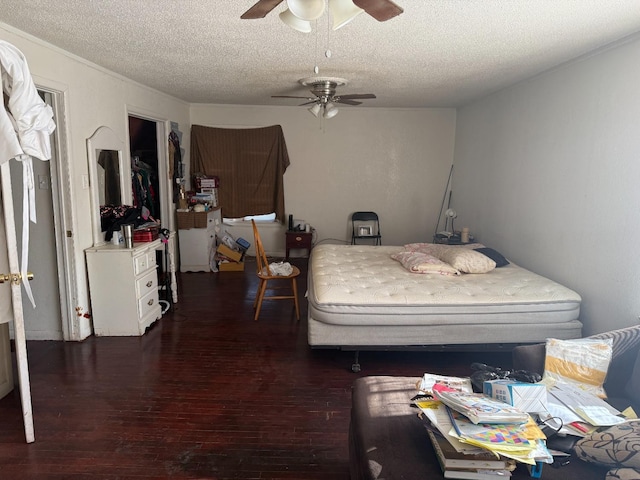 bedroom with dark wood-type flooring, ceiling fan, and a textured ceiling