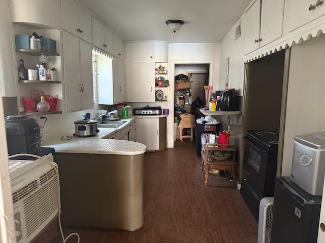 kitchen with dark wood-type flooring, black electric range, sink, and white cabinets