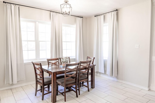 dining area with baseboards and a chandelier