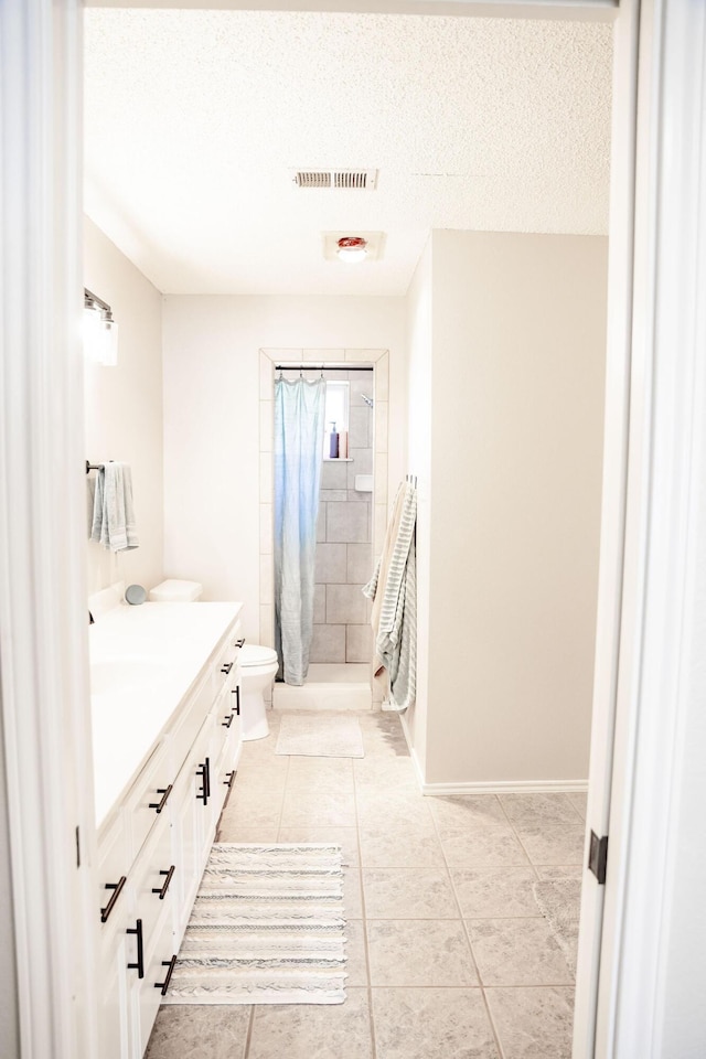 full bathroom with visible vents, a shower stall, toilet, vanity, and tile patterned flooring