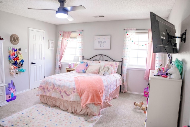 bedroom with multiple windows, visible vents, carpet, and a textured ceiling