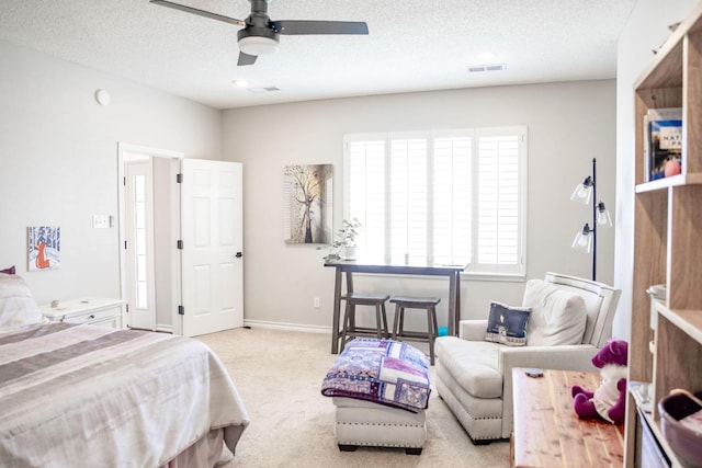 carpeted bedroom featuring baseboards, visible vents, ceiling fan, and a textured ceiling