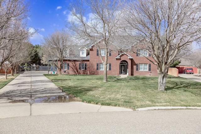 view of front of home featuring a front yard, fence, brick siding, and concrete driveway