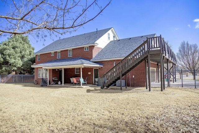 back of house with stairs, cooling unit, fence, brick siding, and a patio