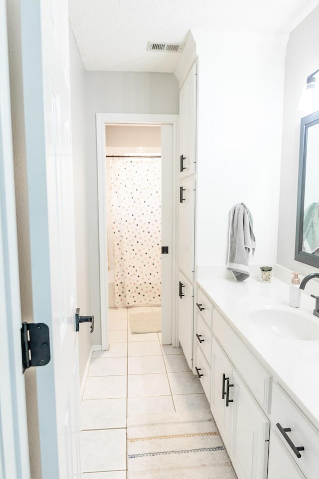 bathroom featuring tile patterned floors, a shower with shower curtain, vanity, a textured ceiling, and visible vents
