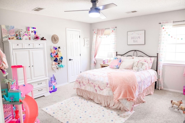 bedroom featuring carpet flooring, visible vents, multiple windows, and a textured ceiling