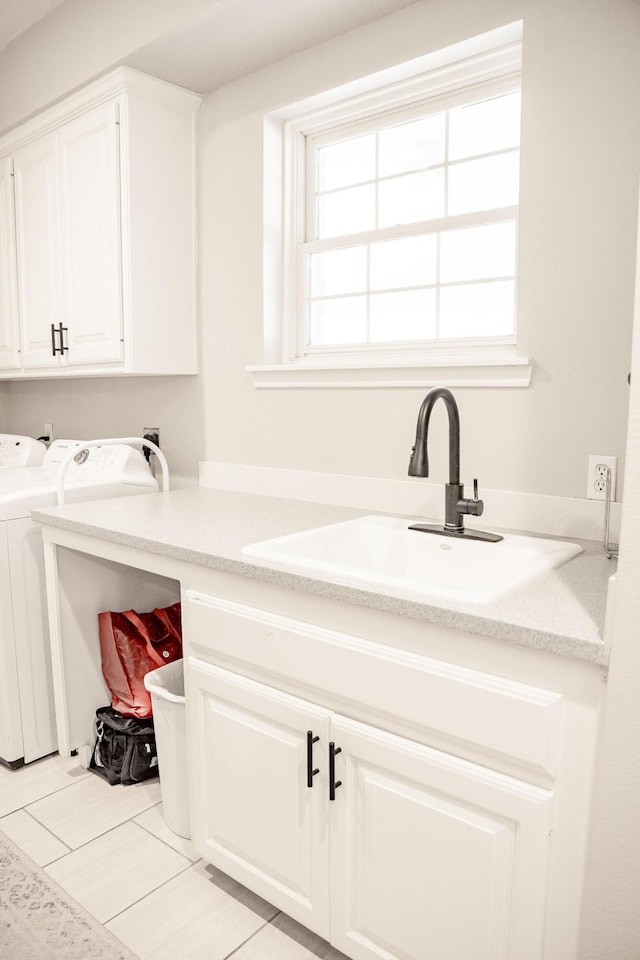washroom featuring washing machine and dryer, cabinet space, and a sink
