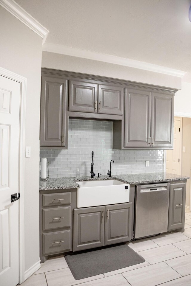 kitchen with stainless steel dishwasher, gray cabinetry, and a sink