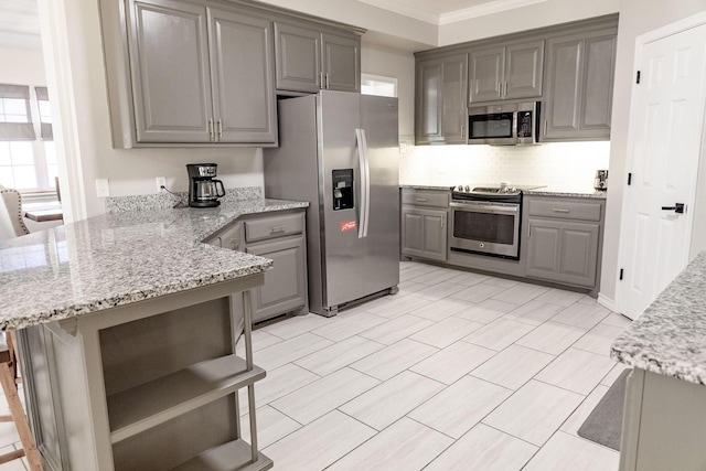 kitchen featuring gray cabinets, a peninsula, tasteful backsplash, and appliances with stainless steel finishes