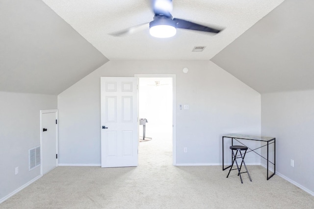 additional living space with carpet floors, visible vents, vaulted ceiling, and a ceiling fan